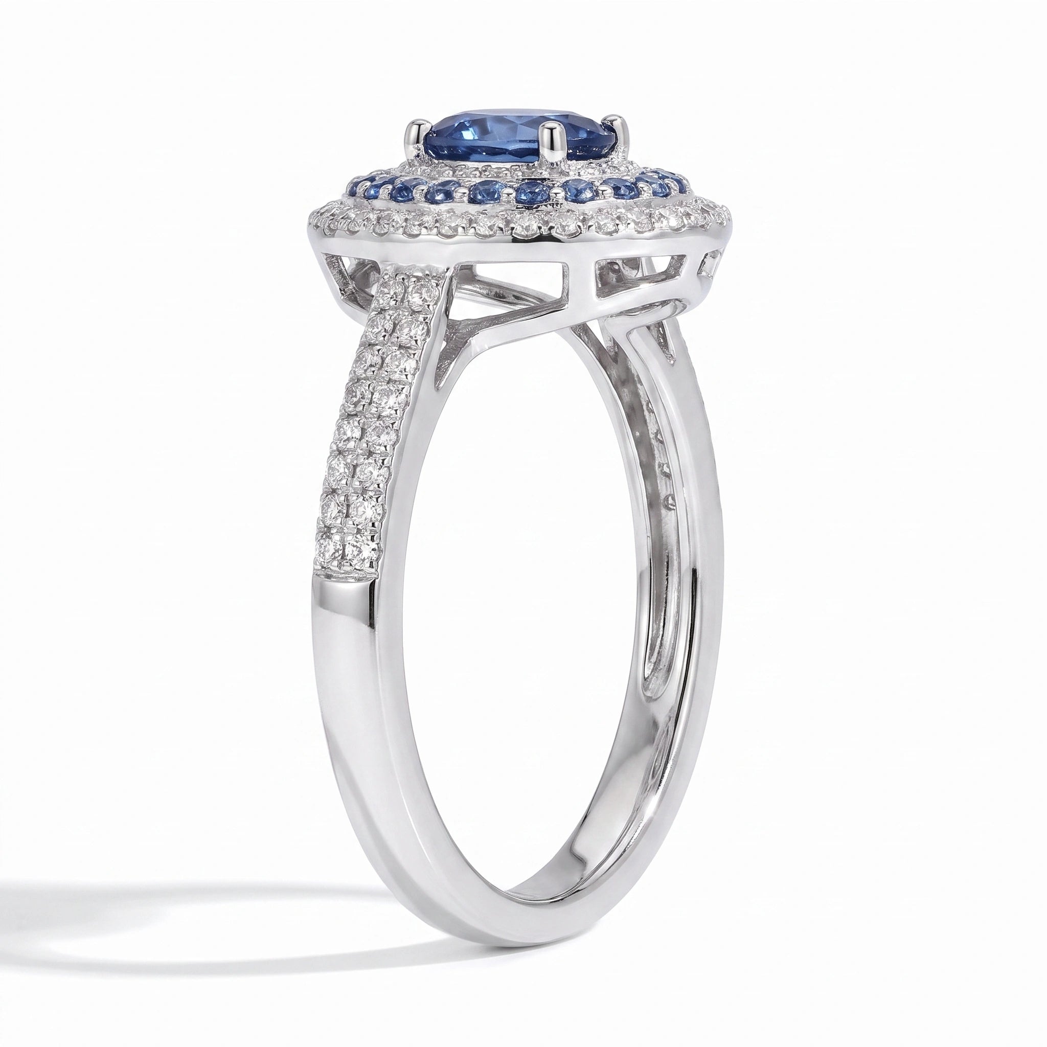 Oval blue moissanite double halo ring angled on white background
