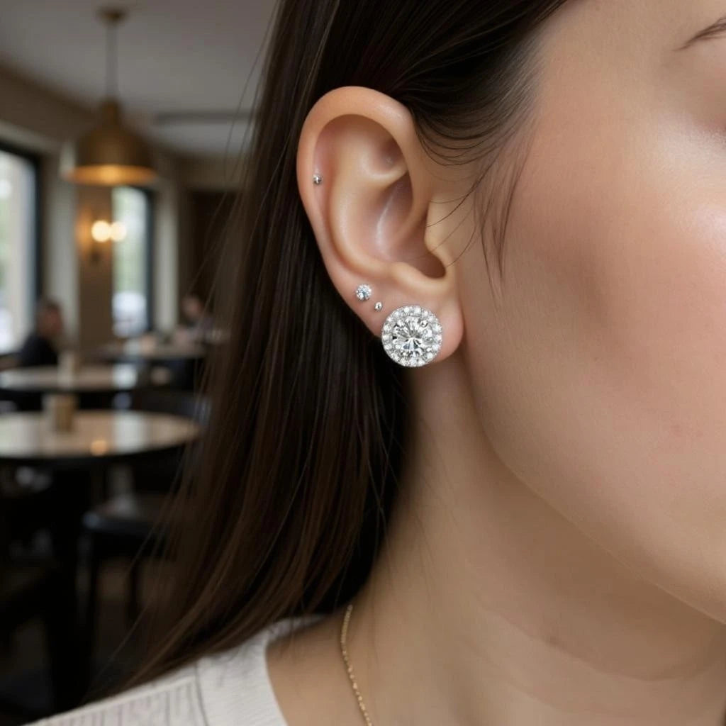 Close-up of a person wearing diamond earrings in an indoor setting.