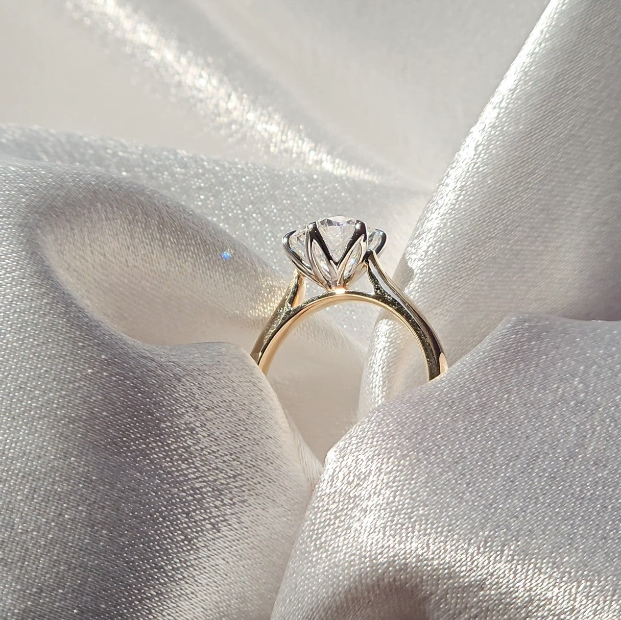 Tulip round solitaire diamond ring, side profile showing the raised basket