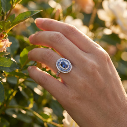 Oval blue moissanite halo ring hero image on white background